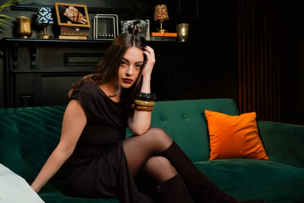 Hazel Rose sitting on a sofa in a quaint room