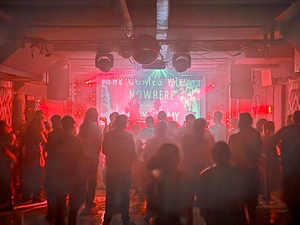 People looking at a red-lit stage